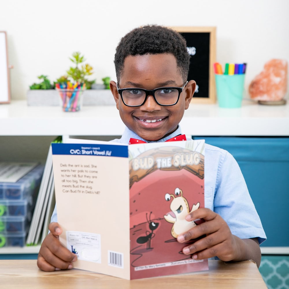 a school-aged child reading a book at his desk