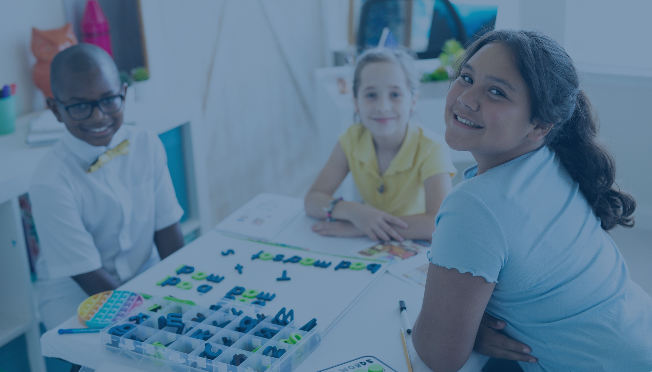 students smiling while learning with tools